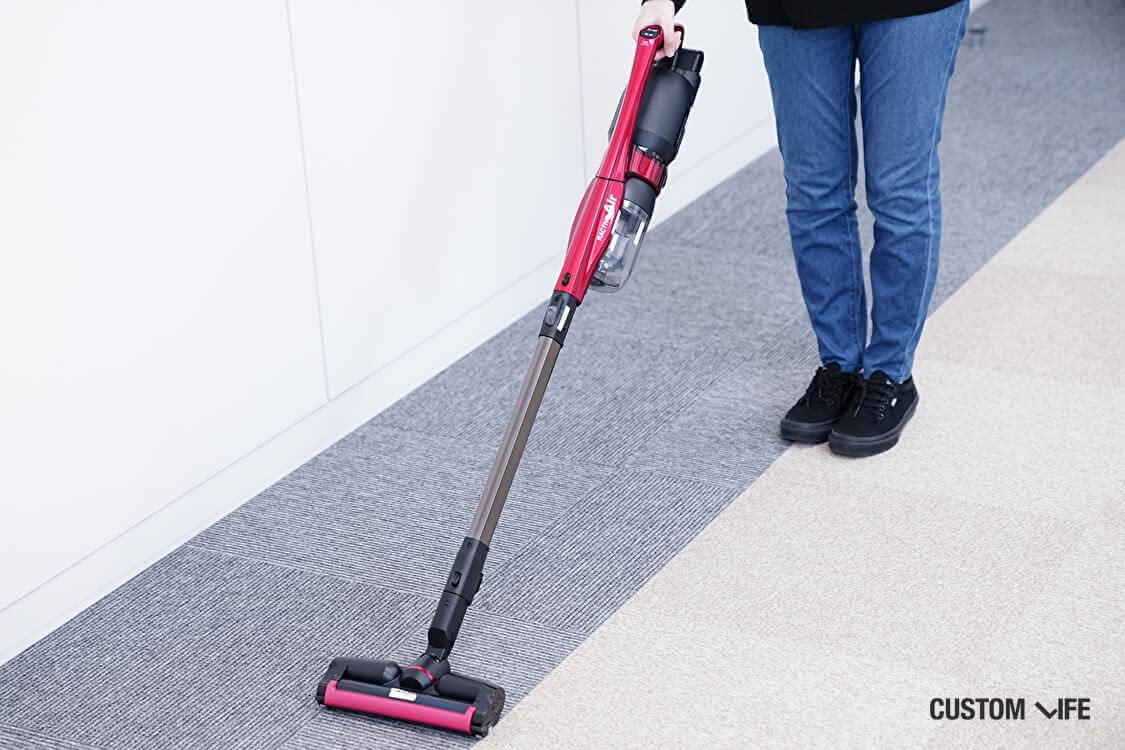 女性が掃除機をかけている場面